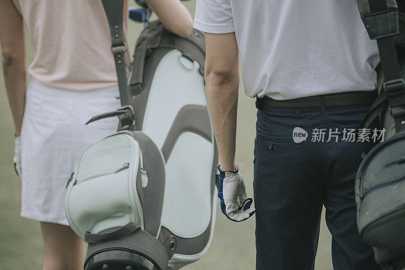 asian chinese couple golfer walking in golf course getting ready to play golf during weekend happily